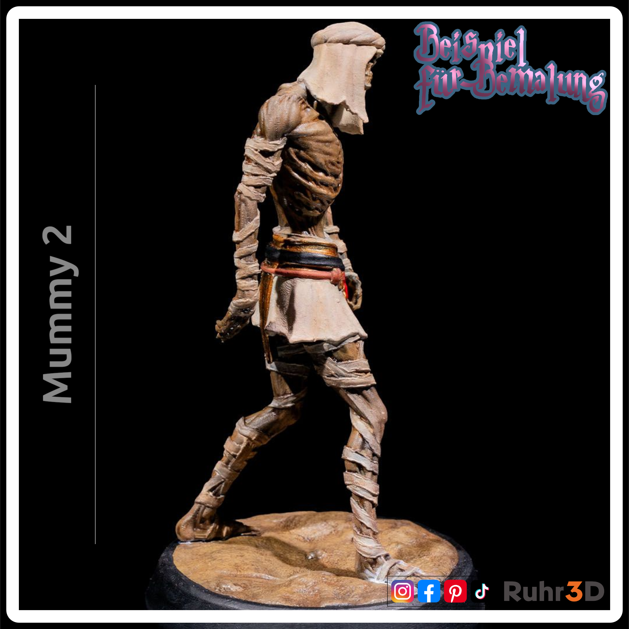 Detaillierte Mumienfigur mit skelettartigem Gesicht und Bandagen. Die Figur hat goldene Akzente an Kragen und Handgelenk sowie einen roten Edelstein am Gürtel. Die Basis ist sandfarben, und die Figur ist mit "Mummy 2" beschriftet.