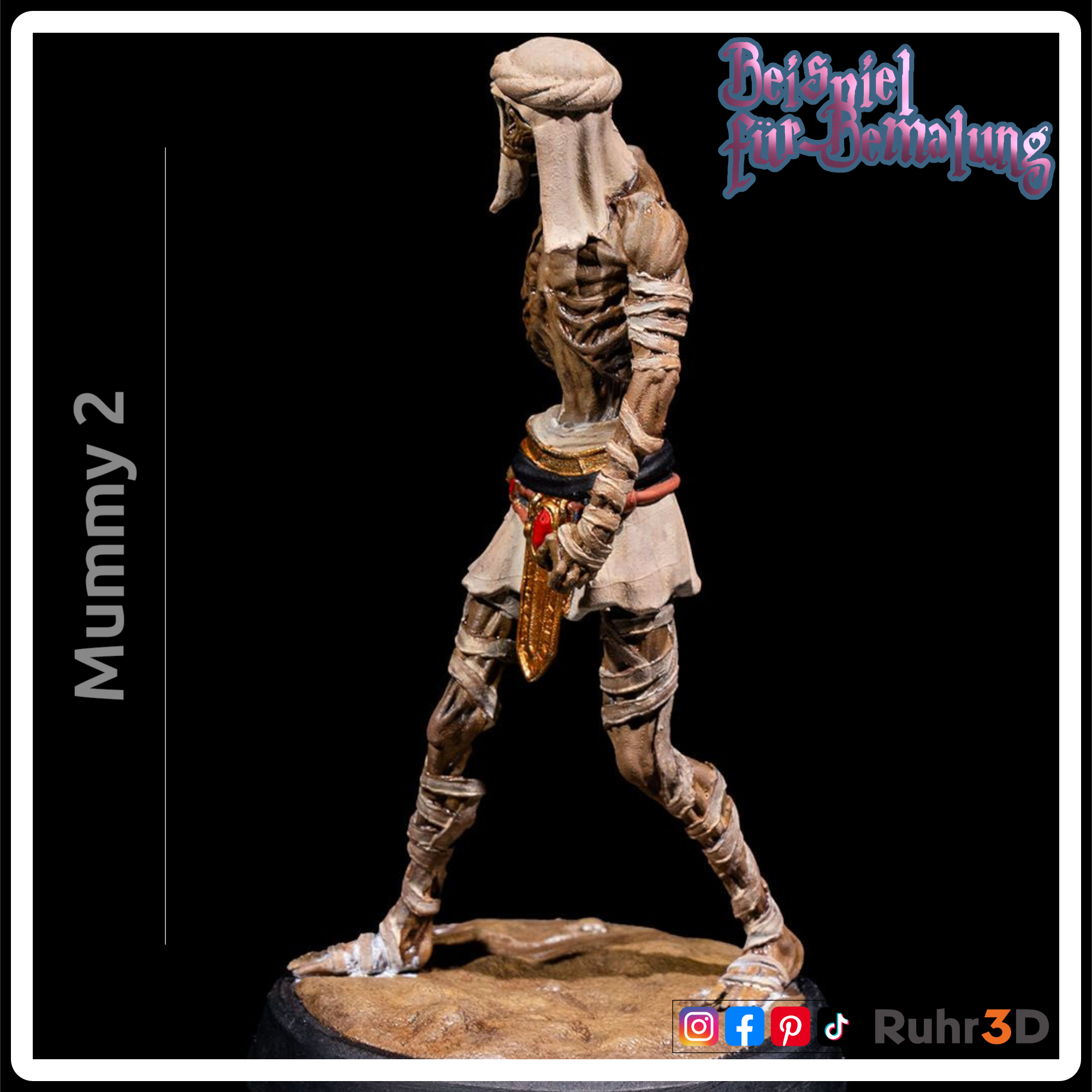 Detaillierte Mumienfigur mit skelettartigem Gesicht und Bandagen. Die Figur hat goldene Akzente an Kragen und Handgelenk sowie einen roten Edelstein am Gürtel. Die Basis ist sandfarben, und die Figur ist mit "Mummy 2" beschriftet.