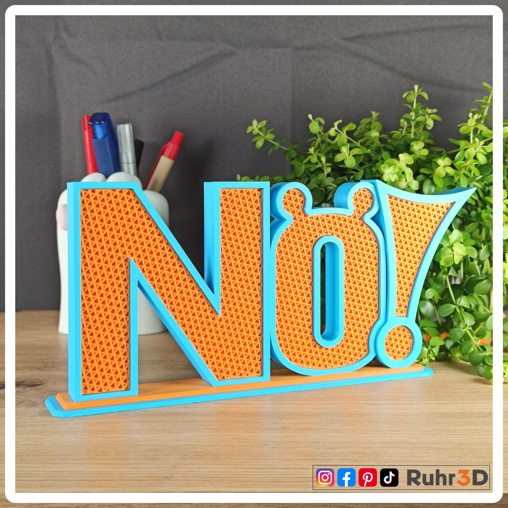 Aufsteller "Nö!" in den Farben Sky Blue und Orange. Die Größe beträgt inklusive Sockel circa 100 mm Höhe * 230 mm Breit * 36 mm Tiefe.