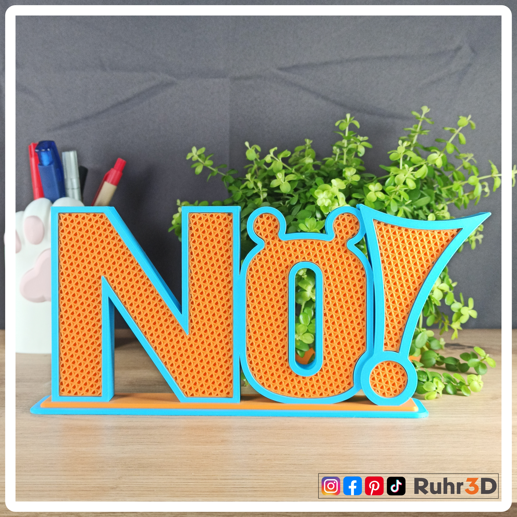 Aufsteller "Nö!" in den Farben Sky Blue und Orange. Die Größe beträgt inklusive Sockel circa 100 mm Höhe * 230 mm Breit * 36 mm Tiefe.